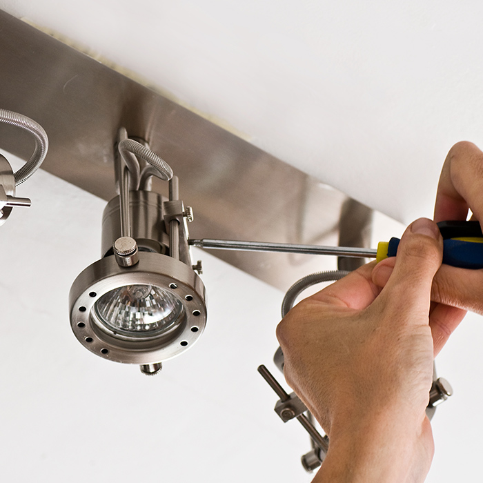 electrician hands with screwdriver close up installing lighting fixtures at ceiling ashland ma